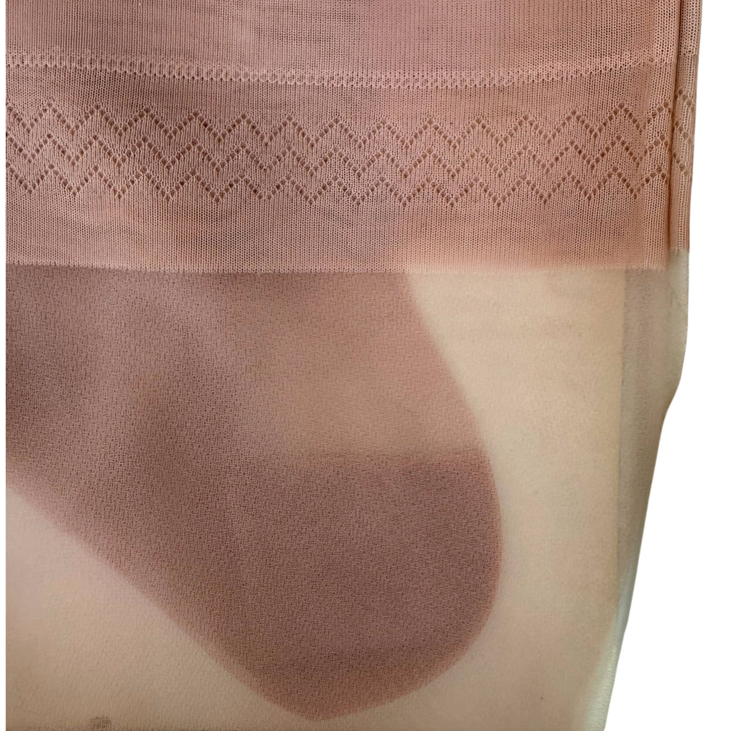 Close-up of a Phantom sheer nude-pink nylon stocking with a zigzag knit pattern at the top cuff, shown on skin.