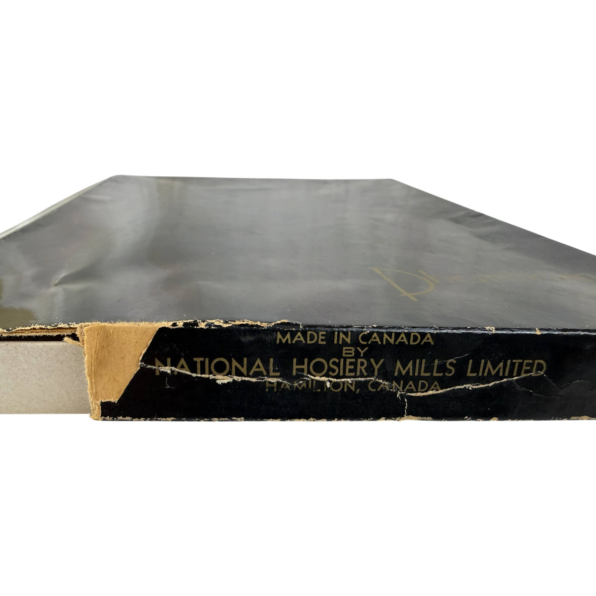 A close-up of a vintage black hosiery box with gold lettering that reads 'MADE IN CANADA BY NATIONAL HOSIERY MILLS LIMITED HAMILTON, CANADA'. 
