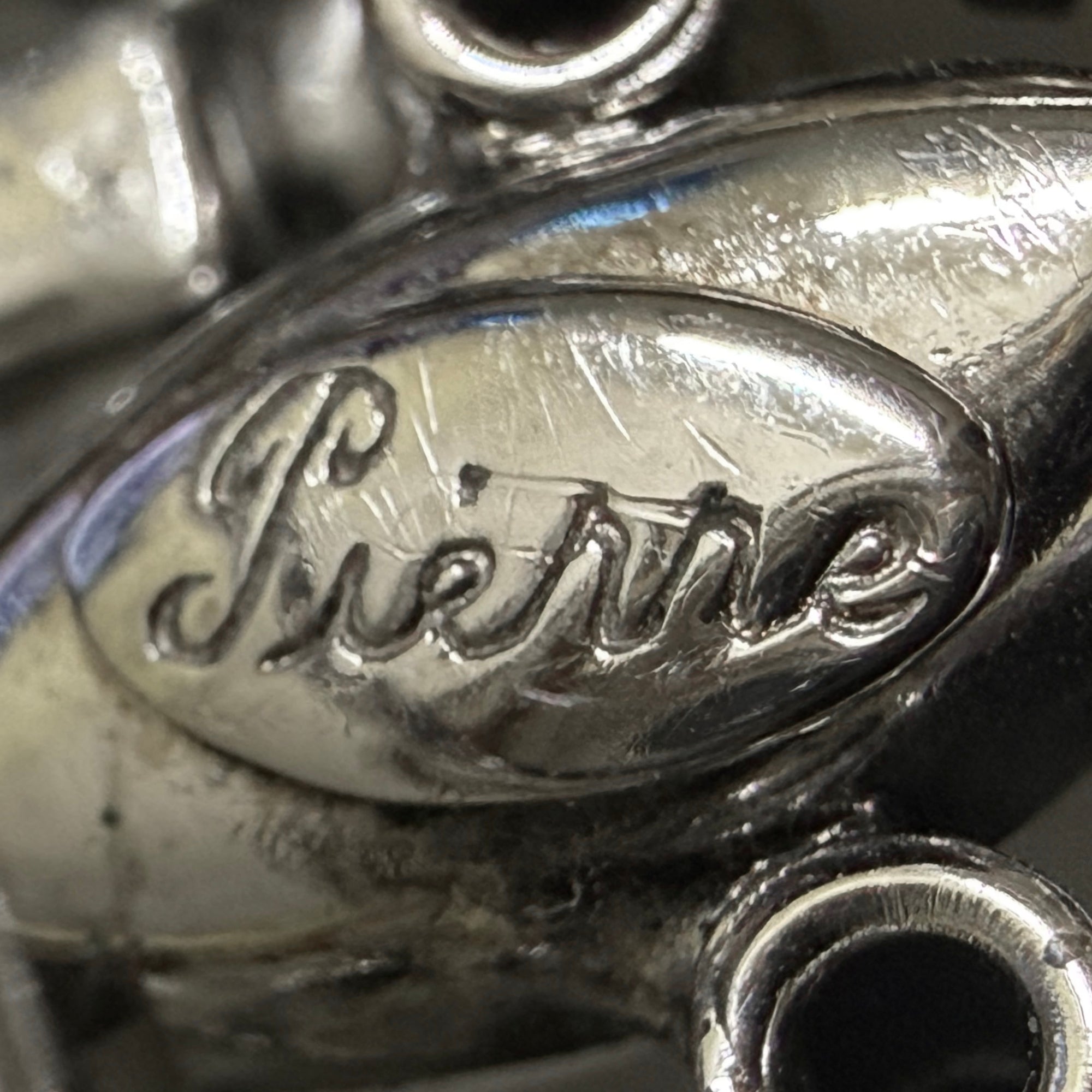 Close-up of Pierre signature on vintage rhinestone brooch