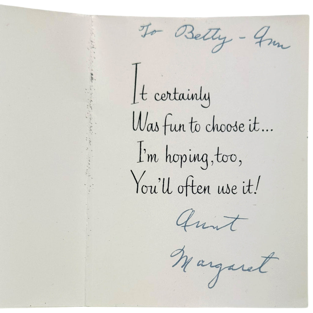 An open vintage paper card with handwritten text addressed 'To Betty - Aunt Margaret'. The card is photographed against a neutral background, showing black and blue ink writing on aged off-white paper.
