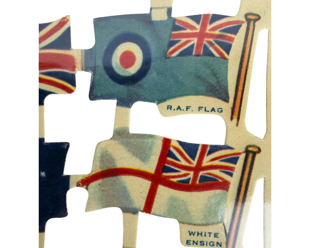 detail of WWII era Raphael Tuck Relief Scraps including the Royal Air Force roundel flag and the White Ensign, with text labels 