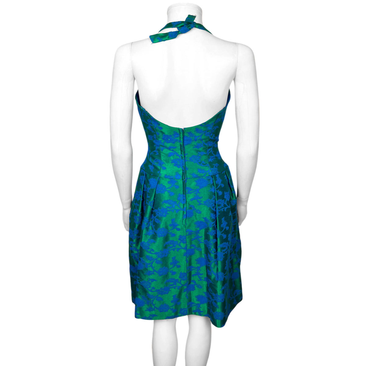 Back of vintage Rappi brocade cocktail dress showing open halter back, fitted waist, centre zipper and pleated skirt