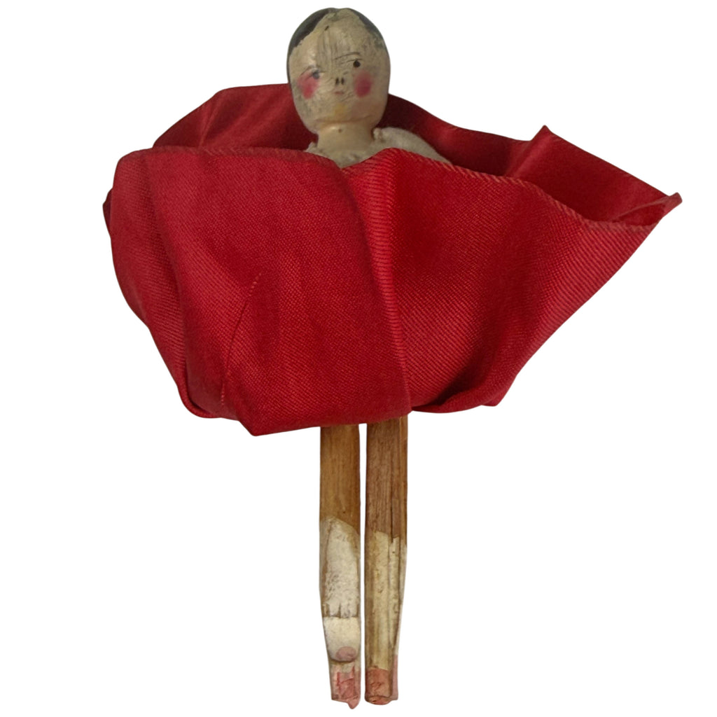 Antique wooden Dutch doll with red silk skirt lifted to reveal articulated wooden legs and remnants of original painted finish