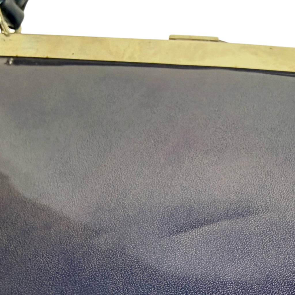 Close-up of indentations on back of vintage purplish blue patent leather handbag