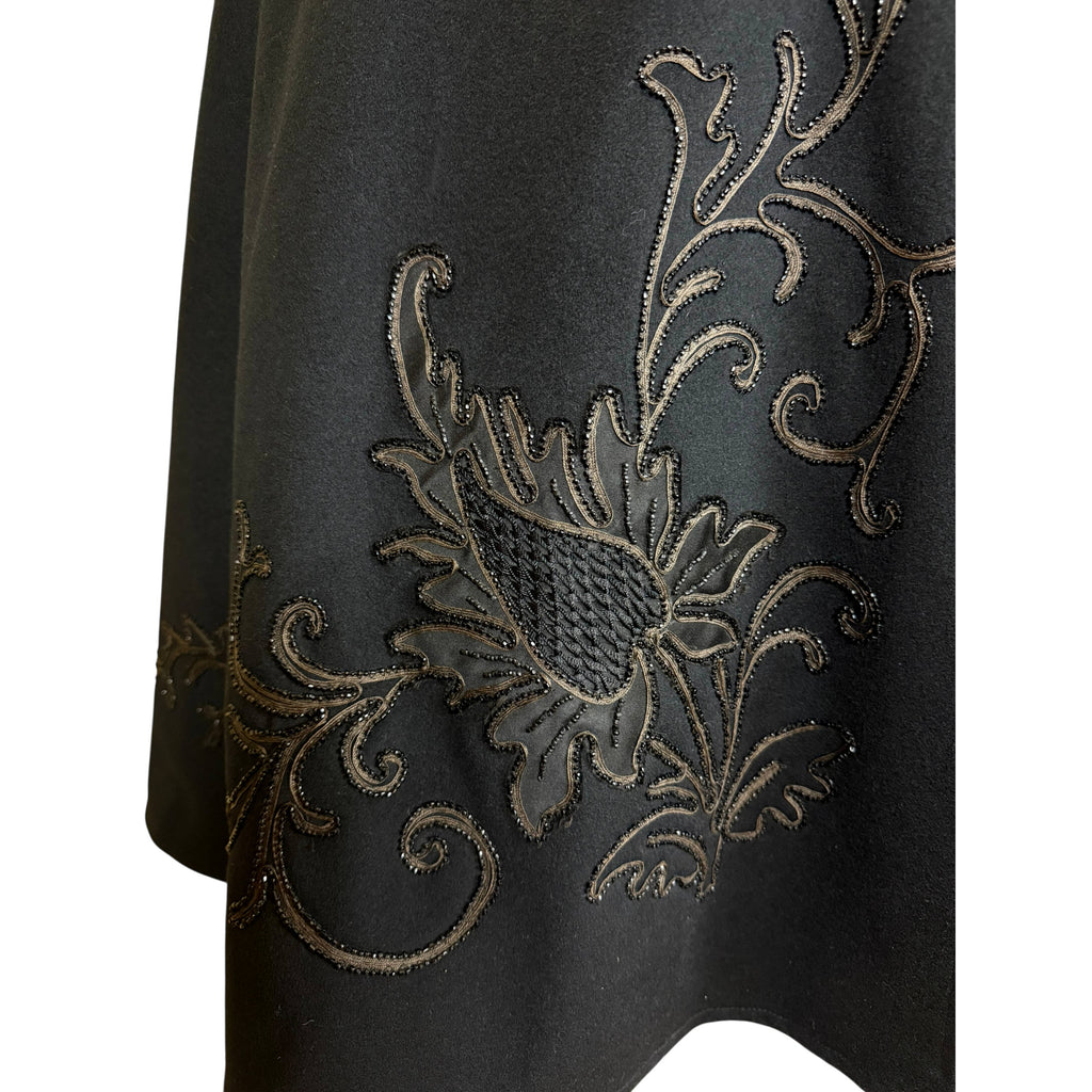 Right front detail of Victorian wool cape showing floral appliqué, corded embroidery and black beading