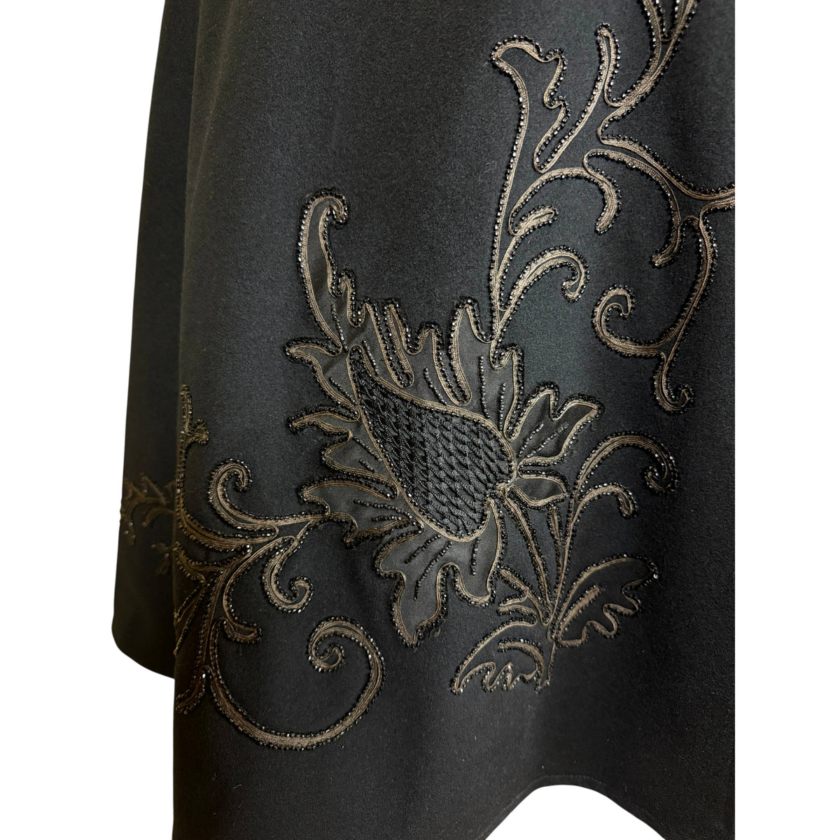 Right front detail of Victorian wool cape showing floral appliqué, corded embroidery and black beading